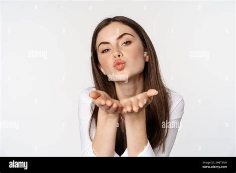 Feminine Woman Sending Air Kiss At Camera Coquettish Flirty Pose Kissing Standing Over White