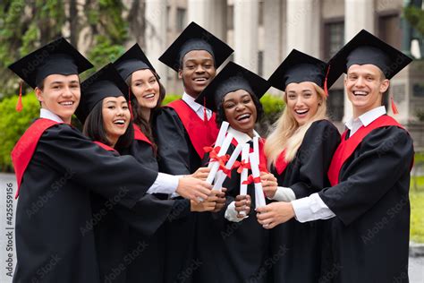 Diverse International Students With Diplomas Celebrating Graduation