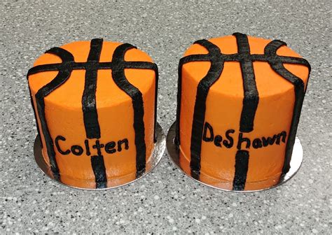Two Cakes Decorated To Look Like Basketballs With Black Ribbon On Them Sitting On A Table