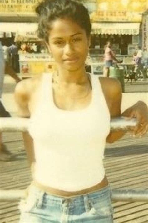 A Woman In White Shirt And Jean Shorts Posing For The Camera
