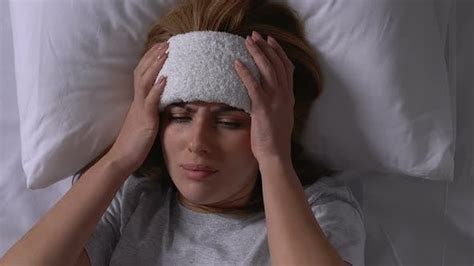 Sick Woman With Towel On Forehead Shivering With Cold In Bed Flu