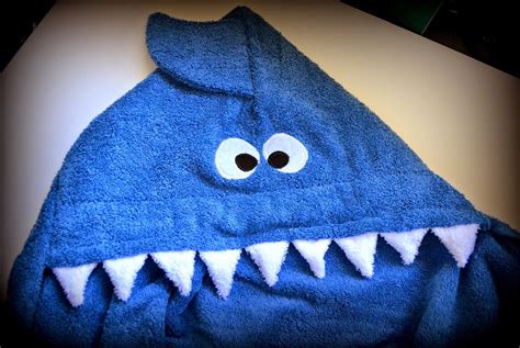 A Blue Shark Towel With Eyes And Teeth On It S Face Sitting On A Table