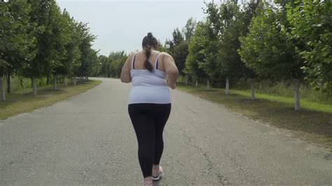 Fat Girl Runs Along The Road Stock Footage Videohive