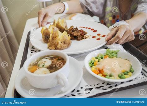 Female Patient Ready To Eat Meal With Varied Menu On Hospital Bed Stock