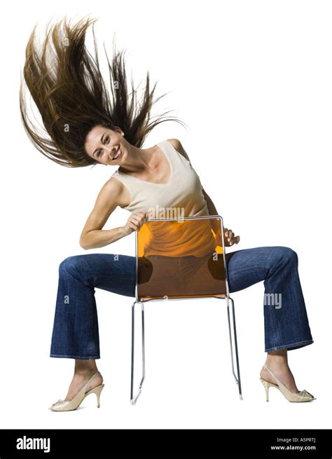 Woman Sitting Backwards On Chair And Tossing Hair Stock Photo Alamy