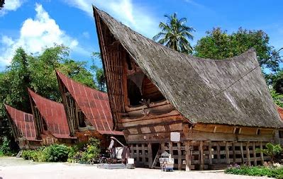 • atap rumah adat batak karo ini bertingkat dengan patung kepala banteng diujungnya. Rumah adat yang ada di Sumatera Utara | INDONESIAKU KINI