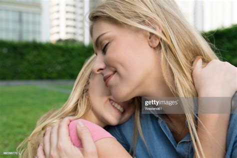 Happy Mother And Daughter Hugging And Smiling In Urban City Garden High