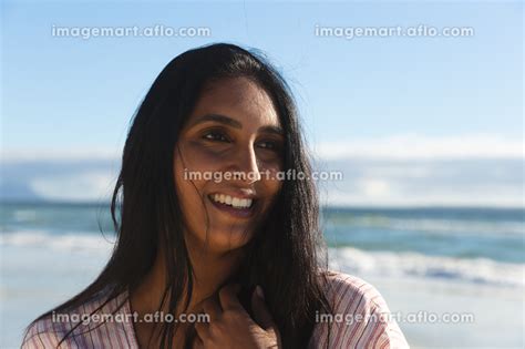 portrait of smiling mixed race woman on beach holiday outdoor leisure vacation time by the sea