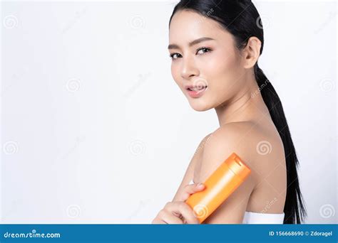 Beautiful Asian Woman Holding And Presenting Cream Tube Product On Beautiful Woman Beauty