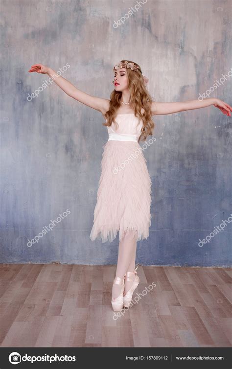 Beautiful Legs Of Young Ballerina Dancing At White Wooden Floor