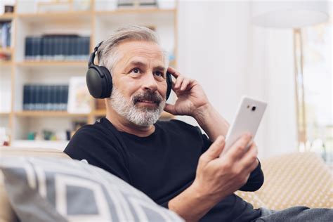 Middle Aged Man Listening To Music Online At Home Deborah Specialty