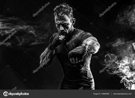 Muscular Man Punching In Smoke Studio Stock Photo By ©zamuruev 148625687