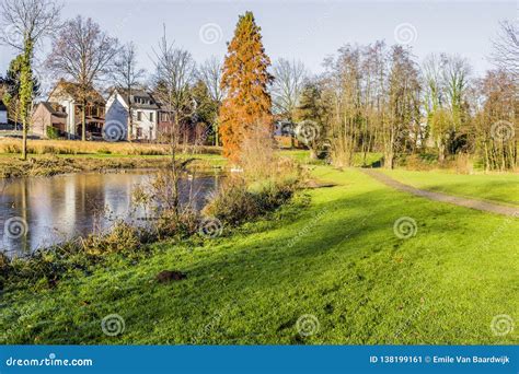 Beautiful Autumn View Of A Lake Surrounded By Green Grass And Trees