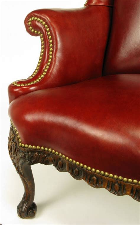 Back legs are moderately carved with a dramatic rake. Regency Red Leather and Carved Walnut Wing Chair at 1stdibs