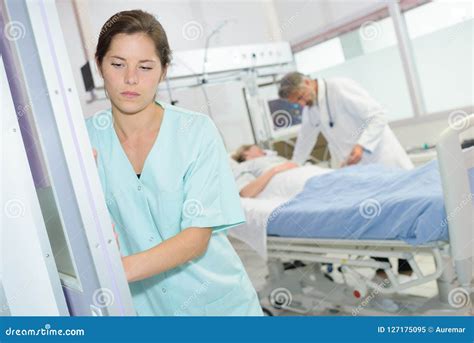 Enfermera De Sexo Femenino Triste En El Pasillo Del Hospital Imagen De