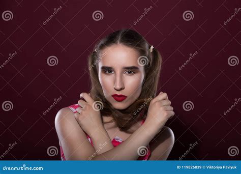 beautiful tanned woman with bright makeup and perfect skin posing over a red background stock