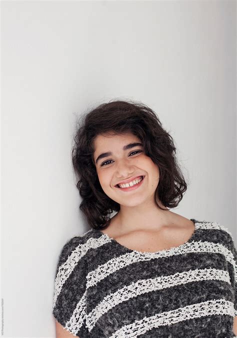 "Portrait Of Young Smiling Woman Leaning On A Wall." by Stocksy
