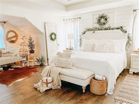 A White Bed Sitting In A Bedroom Next To A Christmas Tree On Top Of A
