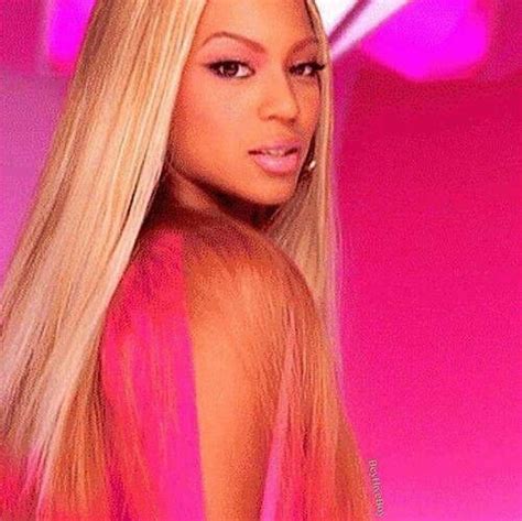 A Woman With Long Blonde Hair Standing In Front Of A Pink Background