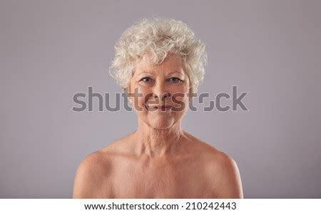 Portrait Of Beautiful Senior Woman Shirtless Against Grey Background