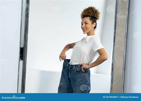 African American Woman Dressed In Big Jeans Before Losing Weight