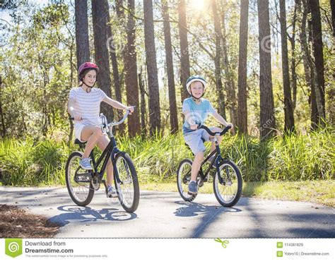 Two Kids Riding Bikes Together Outdoors On A Sunny Day Stock Image