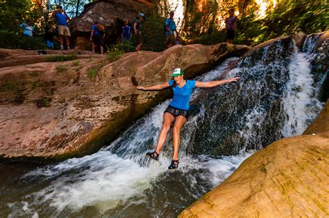 People Sliding Down A Small Waterfall On The Kanarra Creek Falls Hike