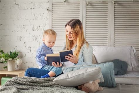 Happy Mother And Son Reading A Book At Home Stock Photo Image Of
