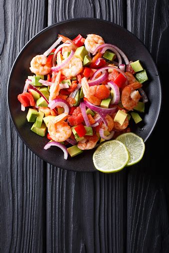 Shrimp ceviche is the perfect appetizer, made with shrimp cooked in lemon and lime juice, mixed with tomato, cucumber, avocado, and spicy jalapeños, topped with cilantro and ready in just 30 minutes! Delicious Ceviche Of Shrimp With Vegetables Spices And Lime Close Up On A Plate Vertical Top ...