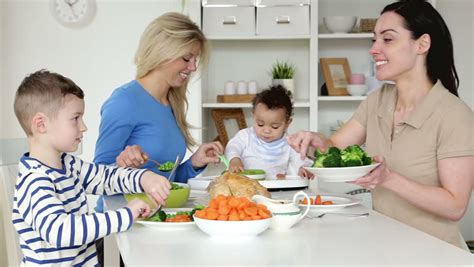 Same Sex Male Couple Having Dinner With Their Son They