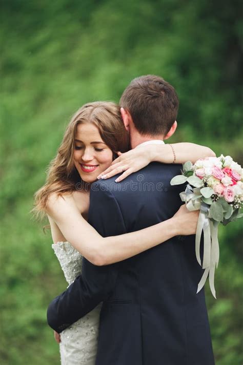 Happy Wedding Couple Hugging And Smiling Each Other On The Background
