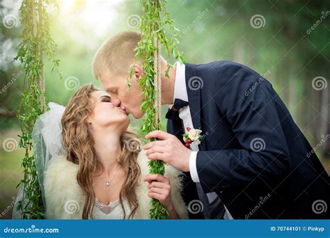 The Groom Is Kissing The Bride On A Swing Stock Image Image Of Spring