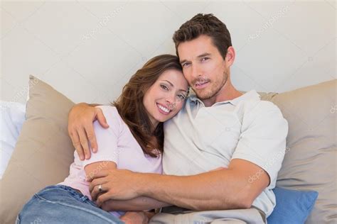 portrait d un couple d amoureux assis sur le canapé — photo 42597877