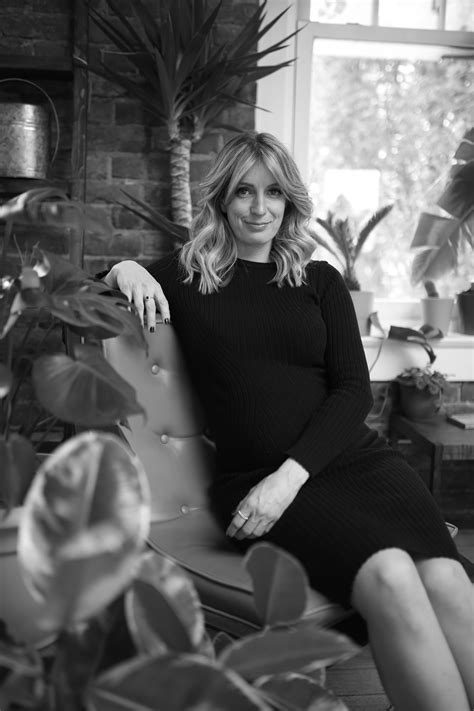 A Black And White Maternity Photo Shoot Of A Woman In A Black Dress Surrounded By Plants By