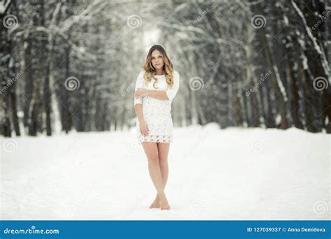 Beautiful Young Woman In A Light Dress And Barefoot In The Snow Stock