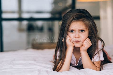 Cute Little Girl With A Sad Face Lying On The Bed Stock Image Image
