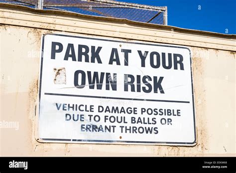 Park At Your Own Risk Sign Placed Behind A Baseball Field San Diego