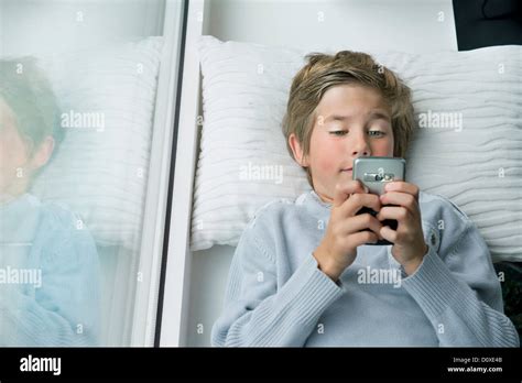 Boy Lying Down With Mobile Phone Stock Photo Alamy