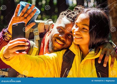 African American Mixed Race Couple In Forest Making Selfie Stock Photo