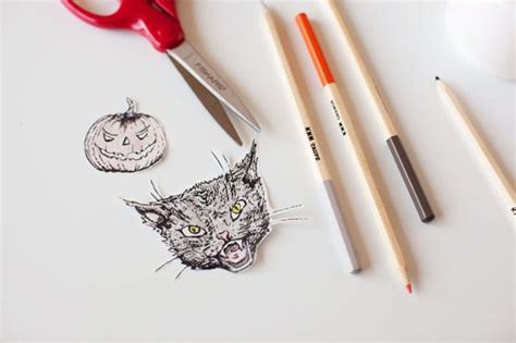 Some Pencils Are Laying On Top Of A White Surface With An Image Of A Cat