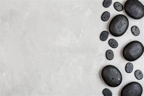 Top View Of Hot Spa Stones Set For Massage Treatment On Gray Concrete Background With Copy Space