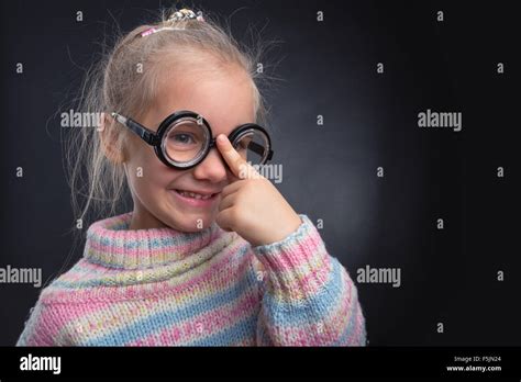Cute Nerd Girl In Glasses Makes Faces Over Grey Stock Photo Alamy