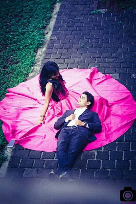A Man Laying On Top Of A Pink Blanket Next To A Woman In A Black Dress