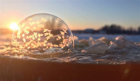 Stunning phenomenon sees bubbles freeze into breathtaking 'snow globe' domes before popping in ...