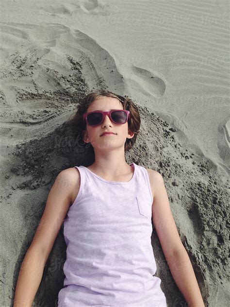 Eleven Year Old Girl Laying On Sand At Beach Del Colaborador De Stocksy Rialto Images Stocksy