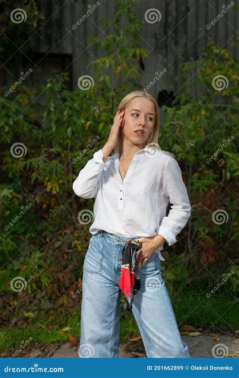 Portrait Of A Young Beautiful Blonde Girl Standing By A Concrete Slab In The Street Stock Image