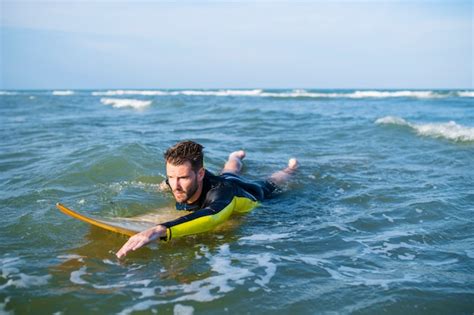 Premium Photo Surfer Paddling Through The Water