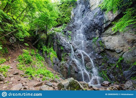 Waterfall In Deep Mountain With Large Rocks In Spring Stock Photo