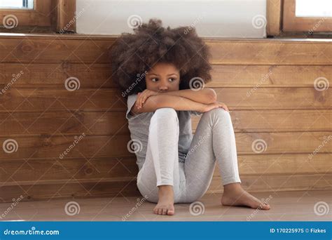 Sad Little African Girl Sitting On Floor Feels Lonely Stock Image