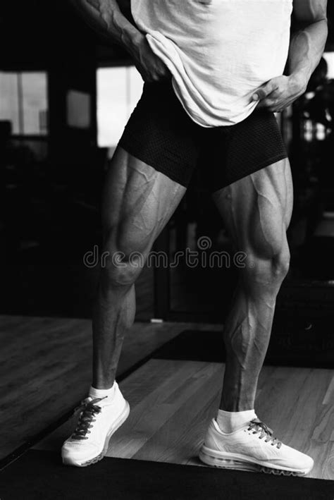 Trained Legs With Muscular Calves In Sneakers In Training Gym During